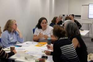 A group of people sit around a workshop table discussing a topic. Photograph from VitaeCon2024. 